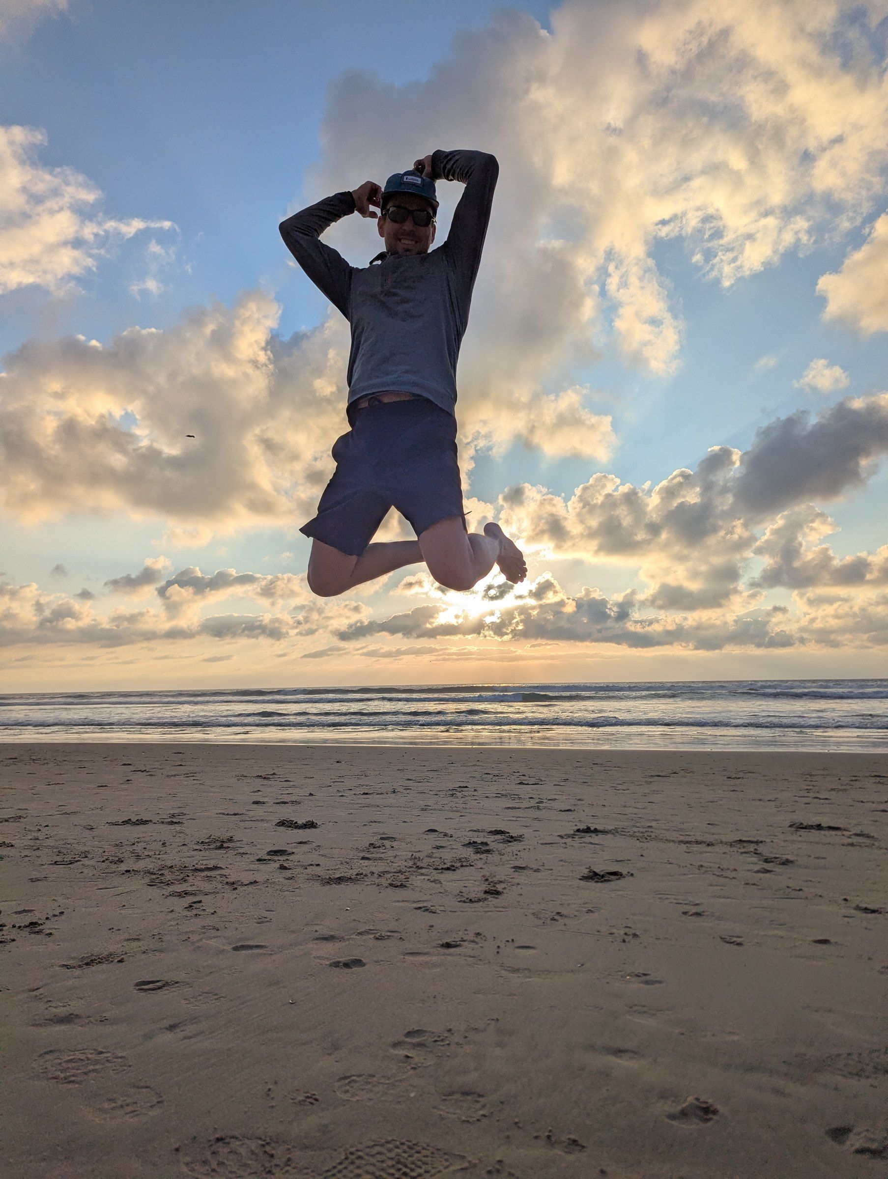 Matthew Siljander jumping on the beach at sunset